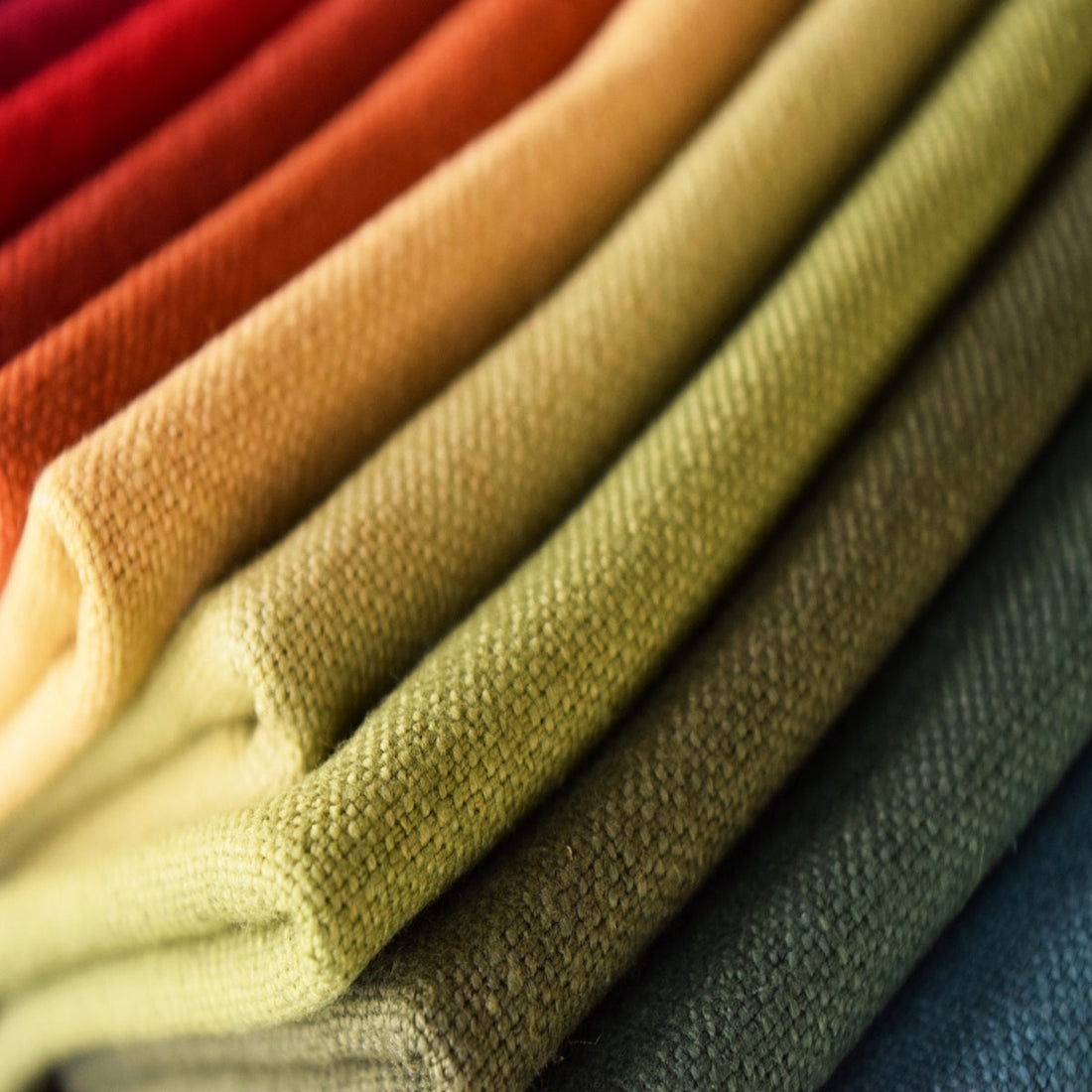 Stack of colorful linen upholstery fabrics.